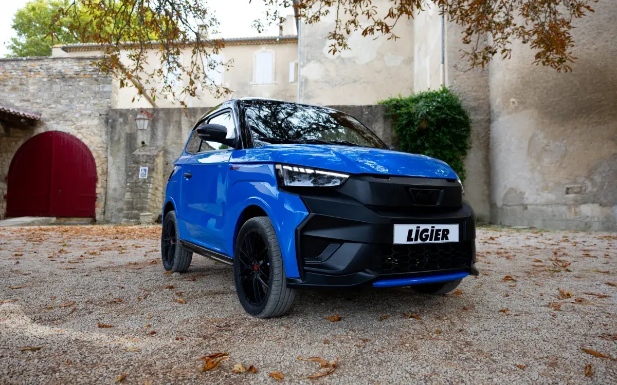 Blauer Ligier JS60 mit schwarzer Front in einem Hof mit Herbstlaub