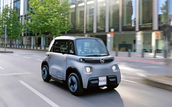 Grauer Opel Rocks fährt durch eine Stadtstraße, schräg von vorne